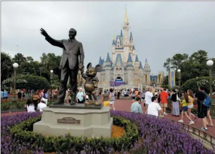  ?? THE ASSOCIATED PRESS ?? In this June 5, 2012, file photo visitors stroll along Main Street at Walt Disney World in Lake Buena Vista, Fla. A new report released this week shows theme park attendance at the largest parks in North America last year was up 2.3 percent, powered by...