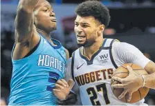  ??  ?? Nuggets guard Jamal Murray, right, drives into Charlotte guard Terry Rozier during the second half on Thursday night.