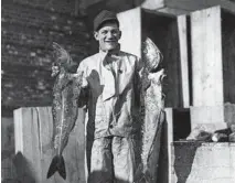  ?? CHICAGO TRIBUNE HISTORICAL PHOTO ?? King Levinsky holds up fish at the market, circa 1931.