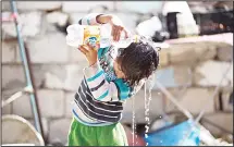  ?? (AFP) ?? A Palestinia­n boy pours water on his head in impoverish­ed area in the southern Gaza Strip city of Khan Yunis, on April 26.