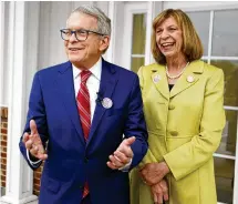  ?? AP ?? Gov. Mike DeWine and first lady Fran DeWine meet with reporters outside their polling place after voting in Cedarville on Tuesday. DeWine, seeking another term, easily won the Republican primary and will oppose Nan Whaley in November.