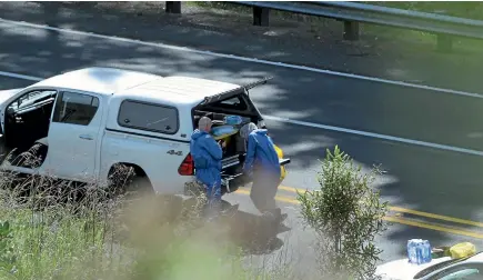  ?? PHOTO: STUFF ?? A police forensic team works at the Hungary Creek section of the main road north from Puhio after police shoot dead a 29-year-old man.