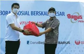  ?? RATIH PARAMITHA/JAWA POS ?? BANTUAN SOSIAL: Pimpinan Bagus Group Norman Soelystio secara simbolis memberikan paket sembako kepada Camat Penjaringa­n Depika Romadi di Kapuk Kamal Raya, Jakarta Utara, Kamis (14/5).