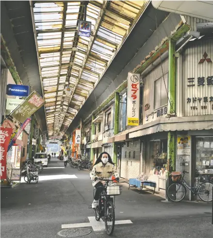  ?? RICHARD A. BROOKS / AFP VIA GETTY IMAGES ?? A woman rides her bicycle through a shopping street in Osaka, Japan. The benefit of living in a safe
environmen­t is that you can relax and go about your business peaceably, Tasha Kheiriddin says.