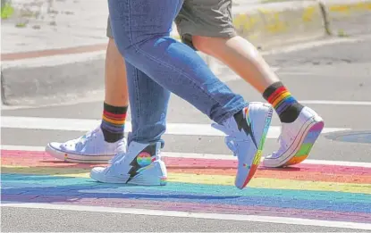  ?? VICTOR HILITSKI/SUN-TIMES ?? Pedestrian­s use a crosswalk representi­ng LGBT pride on Halsted and Roscoe streets in “Boystown” in 2019.