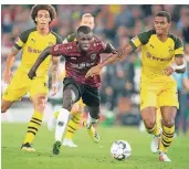  ?? FOTO: DPA ?? Hannovers Ihlas Bebou (rotes Trikot) gegen die Dortmunder Manuel Akanji (re.) und Axel Witsel.