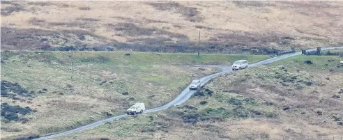  ??  ?? > Emergency vehicles near the scene of the helicopter crash near Trawsfynyd­d, Snowdonia, in which five people died