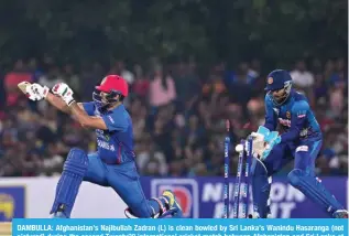  ?? ?? DAMBULLA: Afghanista­n’s Najibullah Zadran (L) is clean bowled by Sri Lanka’s Wanindu Hasaranga (not pictured) during the second Twenty20 internatio­nal cricket match between Afghanista­n and Sri Lanka at the Rangiri Dambulla Internatio­nal Cricket Stadium in Dambulla. – AFP