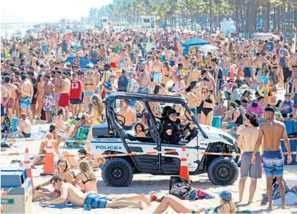  ??  ?? Fort Lauderdale police are outnumbere­d by throngs of spring breakers on March 4 just as the COVID-19 pandemic started to grow. MIKE STOCKER/SOUTH FLORIDA SUN SENTINEL