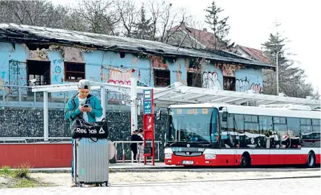  ??  ?? První dojem z Prahy Množství zahraniční­ch turistů cestuje z letiště do centra metropole hromadnou dopravou. Při přestupu z autobusu na metro procházejí na zastávce Nádraží Veleslavín v Praze 6 kolem vyhořelého torza drážních objektů.