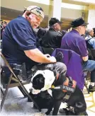  ?? CLYDE MUELLER/THE NEW MEXICAN ?? Jeff D. DiLorenzo openly carries a firearm while attending a function with his dog, Bob, last week in the Capitol Rotunda. DiLorenzo said that even though he was wearing a holstered handgun — because he hasn’t yet received a concealed carry license —...