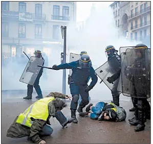  ?? AP/LAURENT CIPRIANI ?? Riot police officers subdue protesters during clashes Saturday in Lyon in central France.
