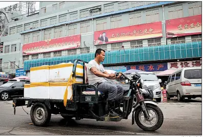  ?? AP/ANDY WONG ?? A seafood delivery driver works Thursday in Beijing where some merchants say they have begun buying seafood, soybeans and other products from countries other than the United States because of U.S. tariffs.