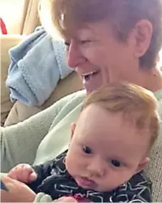  ??  ?? Fit of the giggles: Janice Clark reads to her grandson