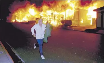  ?? Ken Lubas Los Angeles Times ?? SYLMAR RESIDENT Brian Demetz runs from his burning home on Jan. 17, 1994, after the Northridge earthquake. A report calls for a new push to highlight unresolved risks and convince decision makers to fix them.