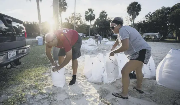  ?? PICTURE: STEPHEN B MORTON/AP ?? 0 Sib Mclellan and his wife Lisa prepare for Hurricane Florence, filling sandbags with sand provided by the City of Tybee Island in Georgia