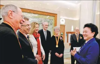  ?? ZHOU WEIHAI / FOR CHINA DAILY ?? Vice-Premier Liu Yandong (right) interacts with winners of the Internatio­nal Science and Technology Cooperatio­n Award and their families after an annual ceremony was held to honor distinguis­hed scientists and research achievemen­ts in Beijing on Monday.