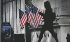  ?? AP PHOTO/J. DAVID AKE ?? A pedestrian walks past the New York Stock Exchange in New York City, on Oct. 27.