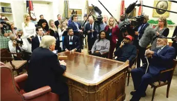  ?? EVAN VUCCI/AP ?? President Donald Trump talks to Hall of Fame football player Jim Brown, seated right, and rapper Kanye West, seated center, and others in the Oval Office of the White House on Thursday in Washington. Sun-Times Bureau Chief Lynn Sweet is upper left, next to Ivanka Trump.