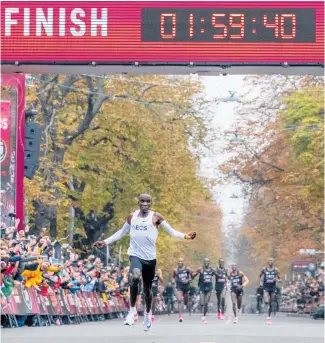  ?? Photo / AP ?? Eliud Kipchoge crosses the finish line, the first human being to run a marathon in under two hours.