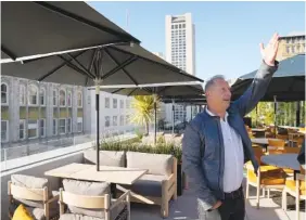  ?? AP PHOTO/ERIC RISBERG ?? Chotto Matte founder Kurt Zdesar points to the surroundin­g view from the rooftop restaurant Oct. 24 in San Francisco.