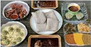  ?? CONTRIBUTE­D BY WENDELL BROCK ?? This takeout feast from Feedel Bistro features (clockwise from upper left): awaze wings; minchet abish key wet; vegan sampler; doro wet; azifah on pita; and injera (center).