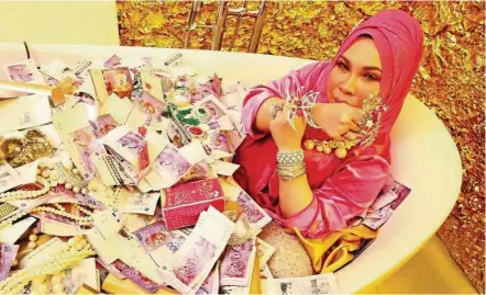  ??  ?? An preview image featuring Vida in a bathtub filled with cash and jewellery has garnered negative reaction on social media. — Instagram