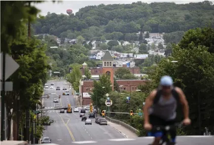  ?? Photos by Matt Rourke, The Associated Press ?? A bicyclist climbs a hill last month in Allentown, Pa. The Pennsylvan­ia city predicts a budget deficit of more than $10 million, a number officials say could go higher if the economy doesn’t turn around quickly.