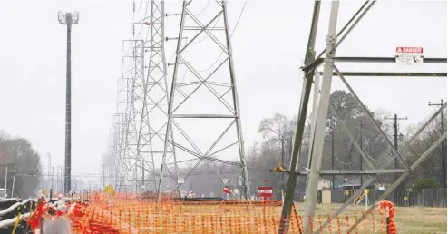  ?? AdreeS LATIF / reuTerS FILeS ?? Overhead power lines are fenced off with temporary orange fencing during record-breaking cold temperatur­es in Houston on Feb. 17.