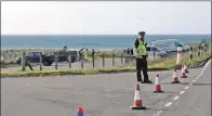  ??  ?? Police cordoned off Westport beach car park. 20_c18surfer0­1