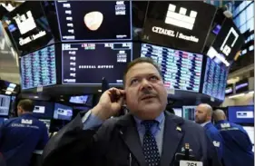  ?? Richard Drew/Associated Press ?? Trader John Santiago works on the floor of the New York Stock Exchange. Stocks edged lower in early trading Monday, extending losses from a broad sell-off last week, as new economic data stoked investors' worries over slowing global growth.