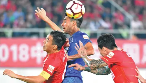  ?? LIU DAWEI / XINHUA ?? Israeli striker Eran Zahavi of Guangzhou R&F rises highest for a header during Friday’s Chinese Super League opener against Guangzhou Evergrande. Zahavi, the 2017 season’s top scorer, picked up where he left off last term, netting a hat-trick as R&F...