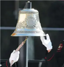  ??  ?? Calgary firefighte­rs ring the bell during the ceremony to honour their fallen comrades on Tuesday.