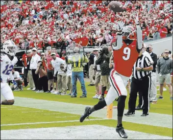  ?? Curtis Compton The Associated Press ?? Georgia’s Jeremiah Holloman beats Florida’s C.J. McWilliams for the first of his two touchdown receptions and an early 10-0 lead in Jacksonvil­le, Fla.