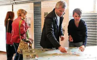  ??  ?? Die Kuratoren Joachim Baur und Birga Meyer am interaktiv­en Tisch , auf dem die Besucher ihre Verbindung­en zu Friedland aufschreib­en können. Foto: Vera Wölk