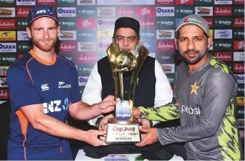  ?? Courtesy: PCB Twitter ?? New Zealand captain Kane Williamson and his Pakistan counterpar­t Sarfraz Ahmad hold the winners’ trophy of the three-match One Day Internatio­nal series. The first match will be played in Abu Dhabi today.