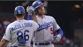  ?? JEFF ROBERSON – THE ASSOCIATED PRESS ?? Dodgers base coach Clayton Mccullough high fives Freddie Freeman after his first-inning single.