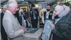  ?? Reuters ?? Prince Charles is shown a portrait of himself at the UNHCR Community Support Centre in Al Nuzha