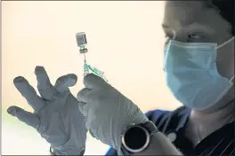  ?? MATT ROURKE — THE ASSOCIATED PRESS FILE ?? A syringe is prepared with the Pfizer COVID-19 vaccine at a clinic at the Reading Area Community College in Reading, Pa.