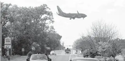  ?? BALTIMORE SUN ?? A plane flies over Dorsey Road in Glen Burnie as it prepares to land at BWI Airport.