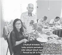  ??  ?? CHUKUP NYAMAI: Norina (duduk) mantaika antara pemakai ti bisi dinah ngagai sida sebuat lebuh ngatur program Projek Pensel ba SK St Paul di Banting, Lingga.