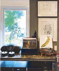  ??  ?? Blue in green: The corner of the studio devoted to music and favorite artists like Miles Davis and The Velvet Undergroun­d overlooks the garden outside with an Igan D’Bayan sculpture from his “Filipinian­a Diabolica” series.