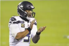  ?? Elsa / Getty Images ?? Seattle quarterbac­k Russell Wilson encourages his teammates during the twominute warning of the fourth quarter.