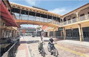  ?? STEPHEN M. DOWELL/ORLANDO SENTINEL ?? Bicyclists ride on Church Street in Orlando on Wednesday. Mike Rogier, who owns Hamburger Mary’s with John Paonessa, expects downtown will be the last place that comes back during the recovery from the coronaviru­s pandemic.