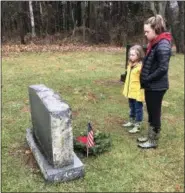  ?? SUBMITTED PHOTO ?? Carly Mack and Juliana Mack take a moment to honor a veteran with a moment of silence during the Wreaths Across America event at St. James Episcopal Church on Germantown Pike in Collegevil­le on Dec. 15.