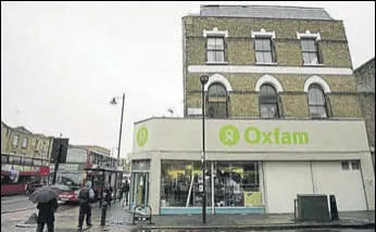 ?? REUTERS FILE ?? People walk past an Oxfam store in Dalston, east London.