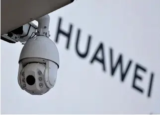  ?? REUTERS ?? A SURVEILLAN­CE CAMERA is seen next to a sign of Huawei outside a shopping mall in Beijing in this Jan. 29 photo.