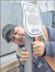  ?? SUEANN MUSICK/THE NEWS ?? Sean Knowles of the Town of Pictou’s public works department installs new placards in the town so visitors and residents can learn some history about the town as they stroll through the streets. The placards have been there in the past but were...