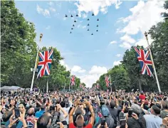  ?? ?? Mobile phone cameras reached for the sky as the formation of 15 Typhoon fighters formed the number ‘70’, to the delight of crowds on The Mall – and Her Majesty herself