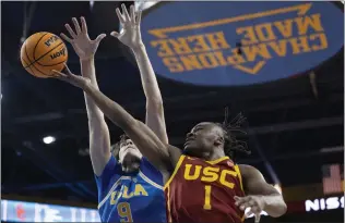  ?? KYUSUNG GONG — THE ASSOCIATED PRESS ?? USC's Isaiah Collier drives to the hoop as UCLA's Berke Buyuktunce­l defends during Saturday's rivalry game